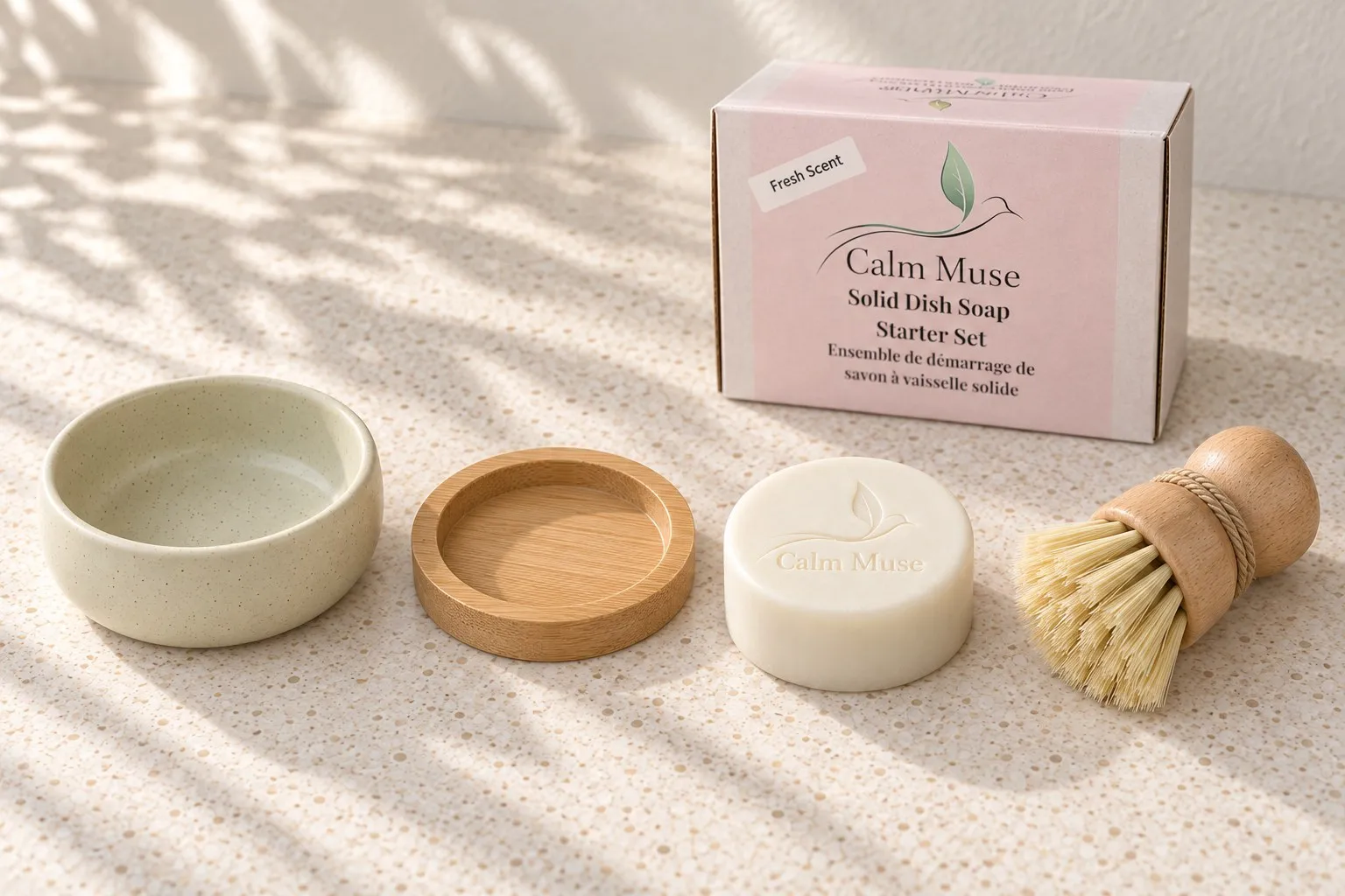 The Calm Muse Starter Set laid out in a row: the ceramic dish, the bamboo insert, a soap puck and the wooden dish brush, with the Fresh Scent box behind